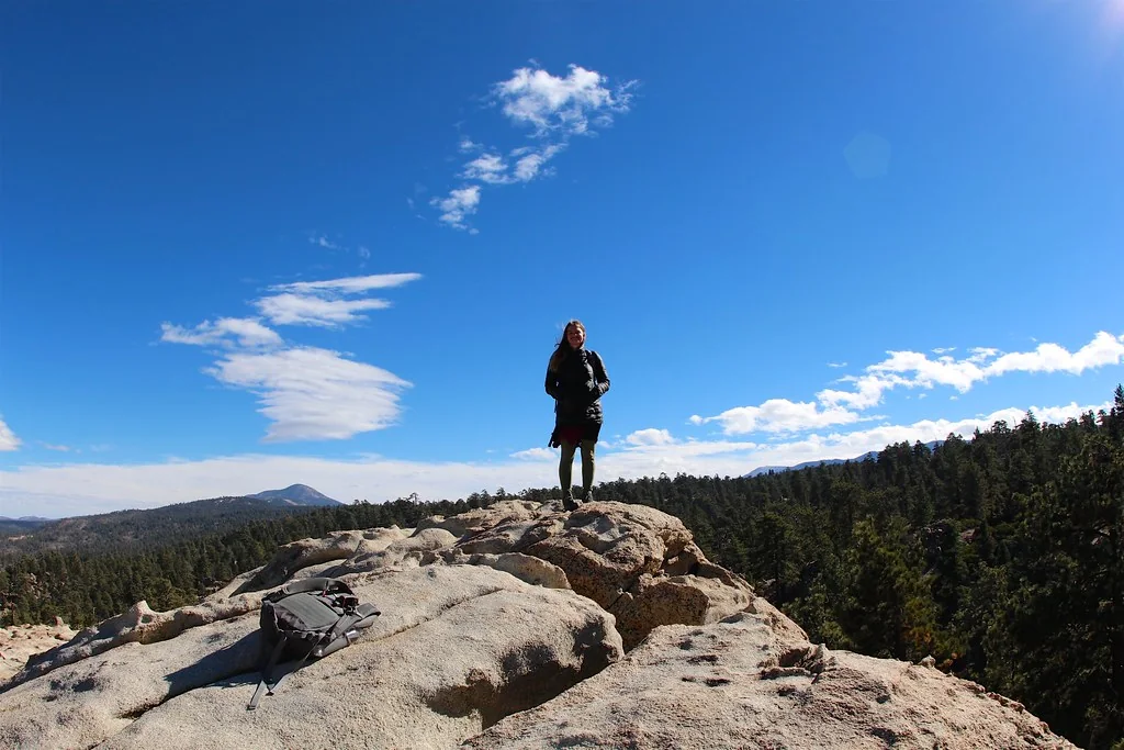 Hiker standing on the granite summit of Castle Rock Trail
